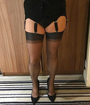 Femme infidèle en lingerie sexy dans le couloir d'entrée de la chambre d'hôtel